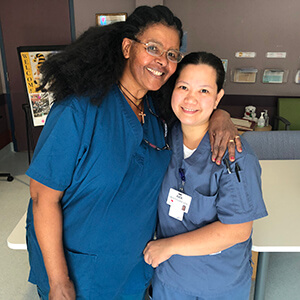 Two smiling Misericordia Place staff posing for camera.